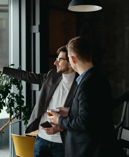 Two colleagues discussing a project by the window